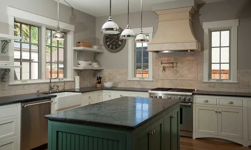 Kitchen in a Burlingame residence with a green island, cream cabinets, a farmhouse sink, and a plaster range hood.