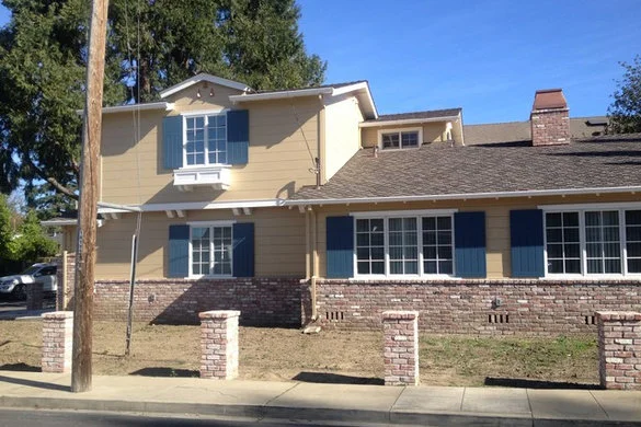 Room addition with a new upper level, brick base, and shuttered windows